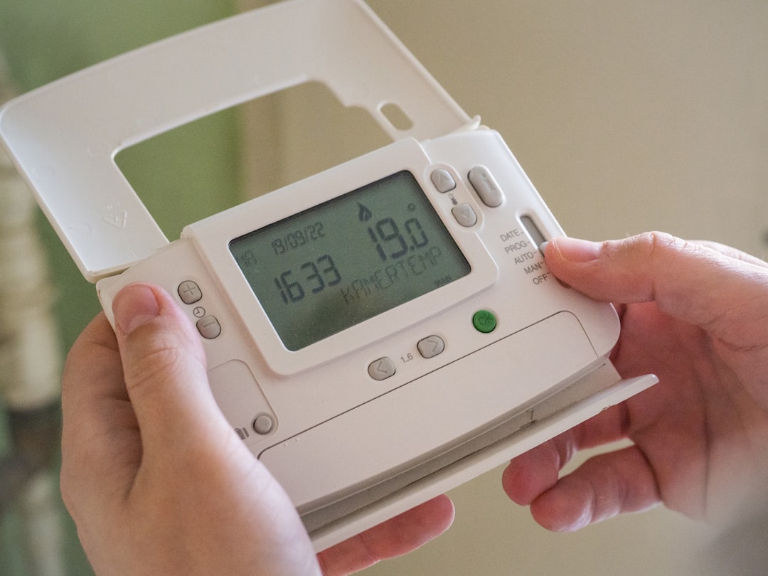 person adjusting air conditioner temperature